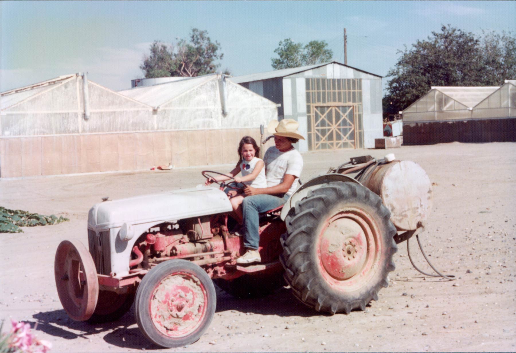 Charles Keenan riding-a tractor with young family member